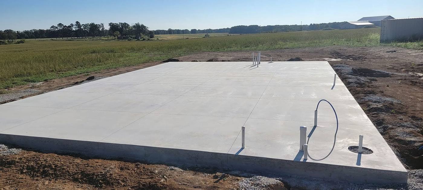Slab foundation with plumbing stub-outs in open farmland