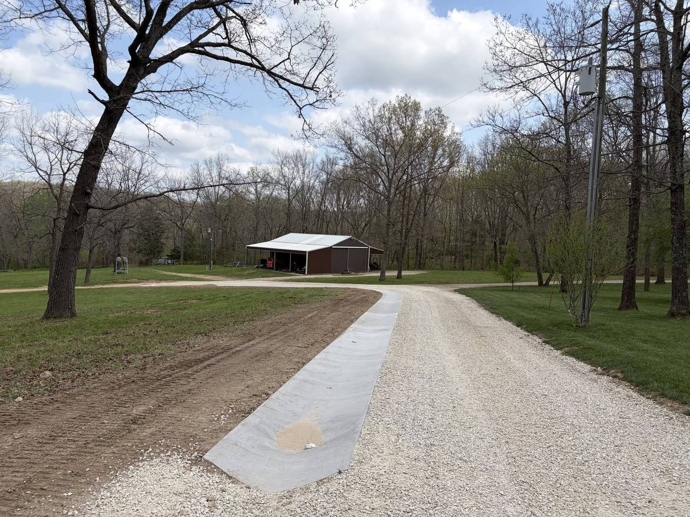 Concrete-edged gravel approach leading to a pole barn